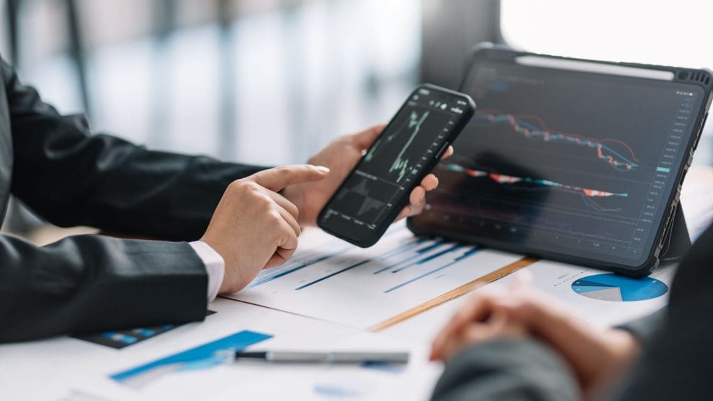 Team businessman brainstorm, plan and analyze stock market charts business financial investment and technology with mobile phone and tablet at office